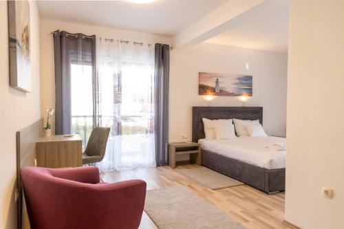 a bedroom with a bed and a chair and a window at Sunny Adriatic in Poreč