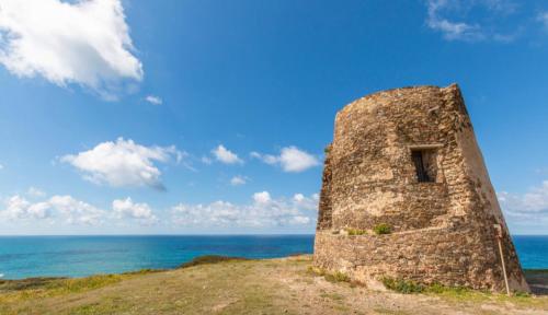 a stone building on top of a hill next to the ocean at -Torre dei Corsari- TERRAZZA SUL MARE in Torre Dei Corsari