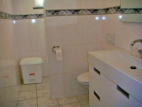 a white bathroom with a toilet and a sink at 4 Persoons Woning met Zwembad. Rustig gelegen. in Figueira e Barros