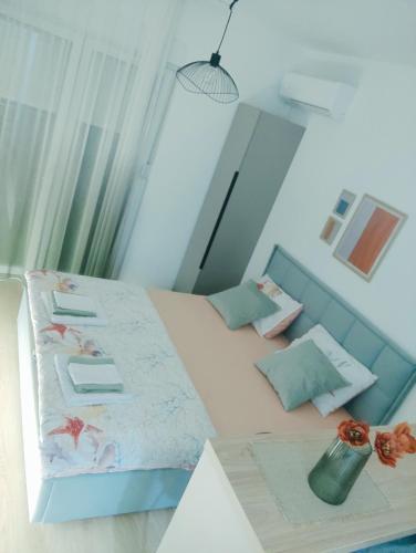a small bedroom with a bed with a blue headboard at Apartman Iskra in Trebinje