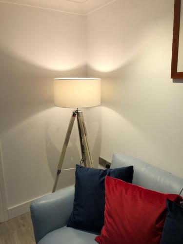 a lamp sitting next to a couch in a room at Stylish Sea View Apartment with Parking in Penzance