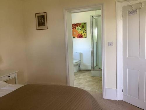 a bedroom with a bed and a bathroom with a toilet at Church house in Claines