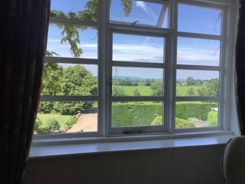 une fenêtre avec vue sur un champ verdoyant dans l'établissement Church house, 