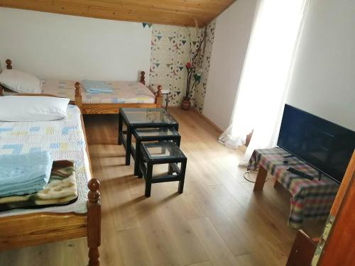 a room with two beds and a table and chairs at Apartmani ,studija i sobe Savić in Soko Banja