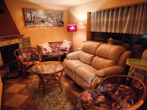 a living room with a couch and chairs and a fireplace at Apartamenty nad Młynówką in Chochołów