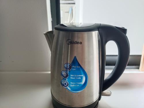 a silver and black coffee kettle with a blue dial at Medini Elysia Park , 3 min to Legoland, Netflix By Hint Homestay in Nusajaya