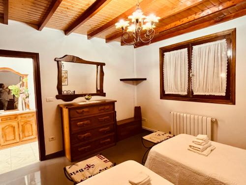 a bedroom with two beds and a mirror at Villa Playa Portomayor BUEU in Bueu