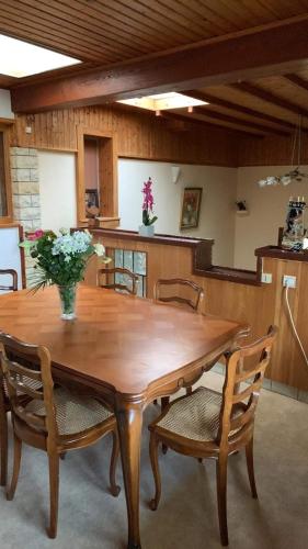 une table de salle à manger avec un vase de fleurs dessus dans l'établissement Maison de vacances, à Frotey-lès-Vesoul