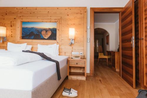 a bedroom with two beds and a door to a room at Gartenhotel Linde 4 Sterne Superior in Ried im Oberinntal