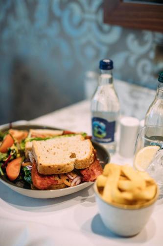 a sandwich and a bowl of salad and a bottle of water at The Valley Hotel & Carriage Gardens in Fivemiletown
