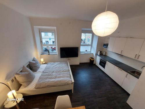 uma sala de estar com uma cama e uma cozinha com uma televisão em Apartments im Mardefeldpalais em Ansbach