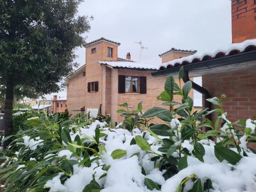 dom pokryty śniegiem przed ogrodem w obiekcie Palazzetto del Pittore w mieście San Quirico dʼOrcia