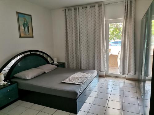 1 dormitorio con cama y ventana grande en Apartman Lana, en Zablaće