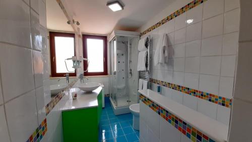 uma casa de banho com um lavatório, um chuveiro e um WC. em Il Sogno Loft Indipendente em Crotone