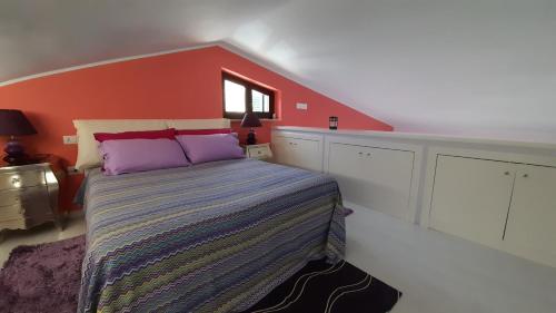 a bedroom with a bed and a red wall at Il Sogno Loft Indipendente in Crotone