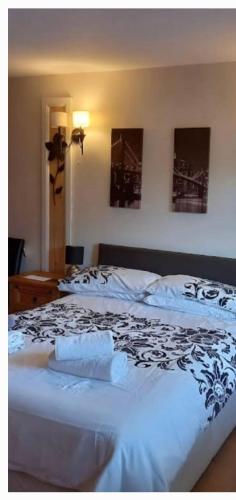 1 dormitorio con 1 cama con manta blanca y negra en The Old Royal George, en Northallerton