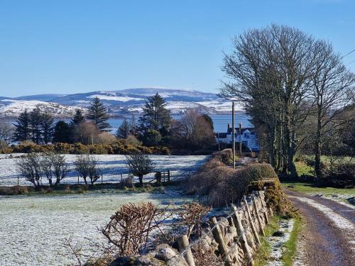a snow covered field with a fence and a road at Balcary Bay Country House Hotel in Auchencairn