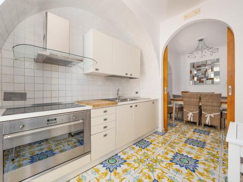 cocina con armarios blancos y suelo de baldosa en Villa Faraglioni 3 Bedrooms with Seaview en Sorrento