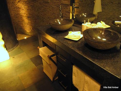 a bathroom with two sinks and two bowls on a counter at Bali Amber Villa in Banjar