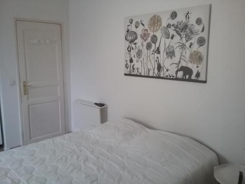 une chambre avec un lit et un tableau au mur dans l'établissement UNE CHAMBRE EN VILLE, à LʼIsle-sur-la-Sorgue