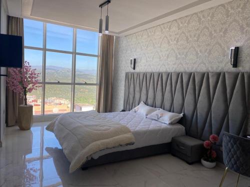 um quarto com uma cama grande e uma janela grande em Hotel Golden Star em Taounate