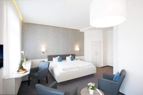 Habitación de hotel con cama, mesa y sillas en Ebner - Boutique-Hotel & Konditorei, en Lindau