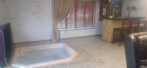 een groot bad in de woonkamer bij Butterfly Guest House in Lekkerrus