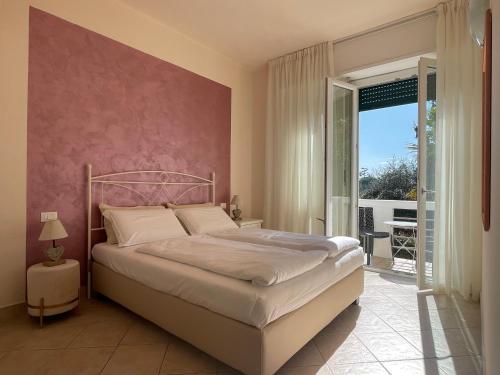 1 dormitorio con 1 cama con pared de color rosa en Betty's House, en Lazise