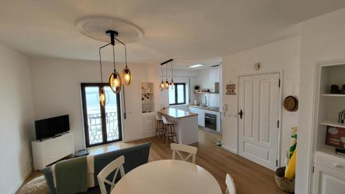 a living room with a table and a kitchen at SonhosQrodopiam Praia da Barra in Praia da Barra