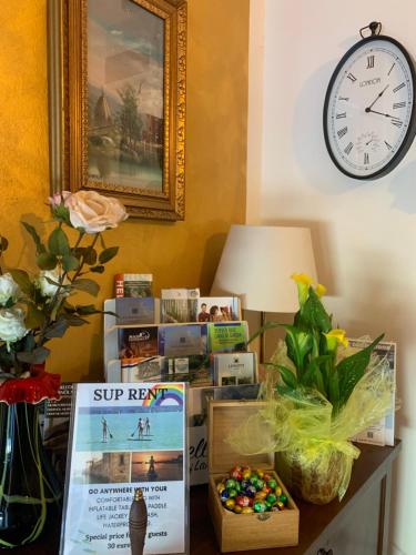 a table topped with a clock and a box of candy at Betty's House in Lazise