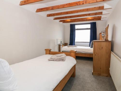 a bedroom with two beds and a window at Waters Edge in Stranraer