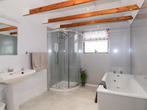 a bathroom with a shower and a tub and a sink at Waters Edge in Stranraer
