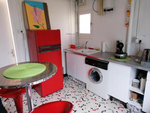 a kitchen with a red refrigerator and a washing machine at Chambre avec Spa et Sauna privatisés in Bourg-en-Bresse