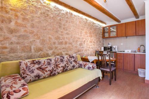 a living room with a couch and a stone wall at Apartment Kalajžić Žeževica in Žeževica
