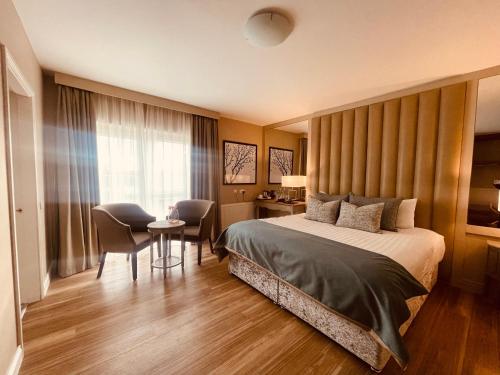 バリナスローにあるMoycarn Lodge & Marinaのベッド、テーブル、椅子が備わるホテルルームです。