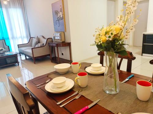 a dining room table with a vase of flowers on it at Medini Elysia Park , 3 min to Legoland, Netflix By Hint Homestay in Nusajaya