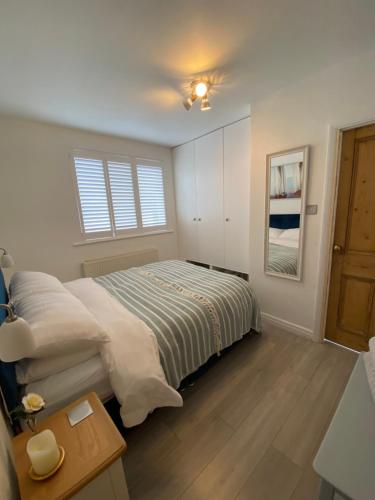 a bedroom with a bed and a window at Little Trevio - seaside haven with parking and sea views in Brixham