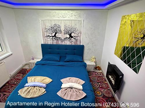 a bedroom with a blue bed with two pillows at Apartament cu 2 camere/Curte privata/La parter/Lux oferim factura in Botoşani