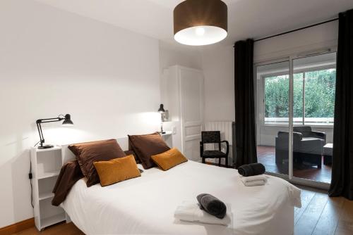 - une chambre avec un grand lit blanc et des oreillers bruns dans l'établissement Appartement Aloa, à Carcassonne