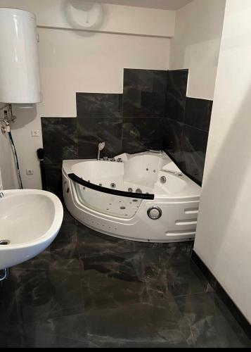 a bathroom with a white tub and a sink at FeWo Teusch Top 6 in Arnoldstein