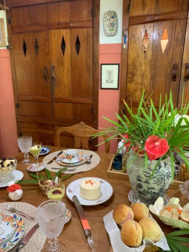 uma mesa com pratos de comida e um vaso de flores em Guest House Tânia Alves em Pratinha