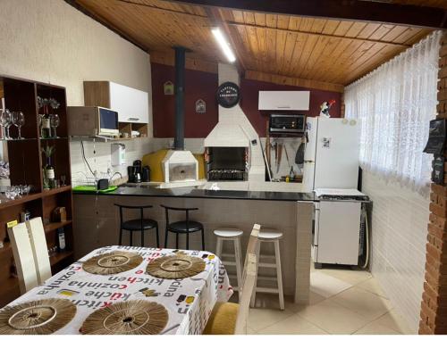 una pequeña cocina con mesa y nevera en Chalé Recanto Sonho Meu, en Visconde De Maua