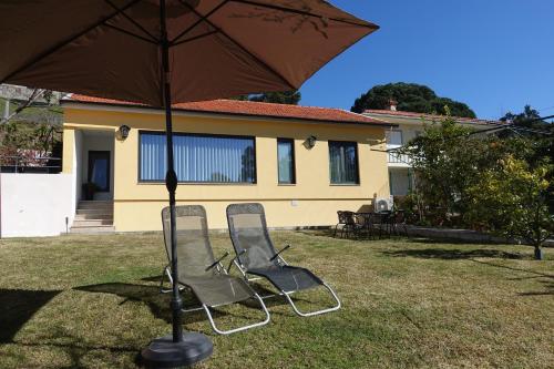 two chairs sitting under an umbrella in a yard at Montinho 313 in Arouca
