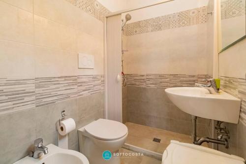 une salle de bain avec des toilettes blanches et un lavabo dans l'établissement CENTRAL SQUARE - San Foca, à San Foca