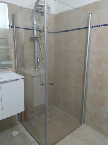 a shower with a glass door in a bathroom at Farber Couple house in Nahariyya