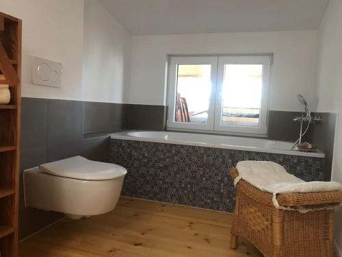 ein Bad mit einer Badewanne, einem WC und einem Fenster in der Unterkunft Dachgeschosszimmer mit Terrasse in Wismar