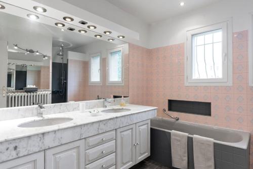 Un baño con dos lavabos y un espejo grande. en Appartement Aloa, en Carcassonne