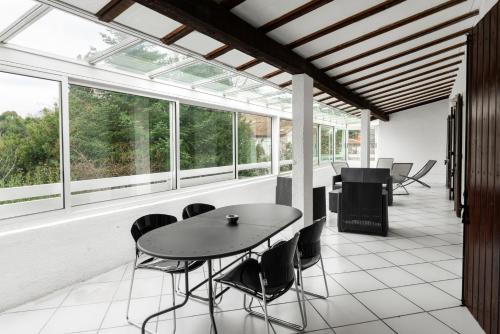 une pièce avec une table, des chaises et des fenêtres dans l'établissement Appartement Aloa, à Carcassonne