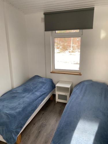 um pequeno quarto com 2 camas e uma janela em Kemping em Föglö