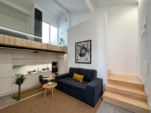 a living room with a blue couch and a table at Apostolos Loft in Évora